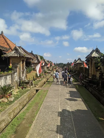 The main walkpath in Penglipuran Tourist Village. Tourists visit this place to experience Balinese traditional culture, buy souvenirs, and create lasting memories. The village's places are designed for walking, not for cars or motorized transport.