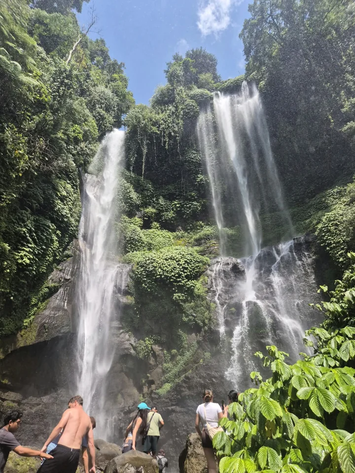 Travellers near a cascading waterfall